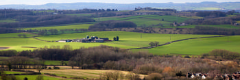 Winter Sutton Scarsdale farm This landscape photograph captures Winter Sutton Scarsdale farm located in the rural countryside near Bolsover, United Kingdom during a late morning in the winter season. The image showcases expansive green fields interspersed with patches of trees and hedgerows, highlighting the presence of nature in the agricultural Landscape. The central focus of the photograph is the farmstead, which consists of several buildings and silos situated amidst open farmland. The distant hills and scattered woodland contribute to the rural ambiance associated with Bolsover, while the muted colours and bare trees are indicative of the winter setting. This landscape demonstrates the connection between nature and rural life in this part of the United Kingdom.
